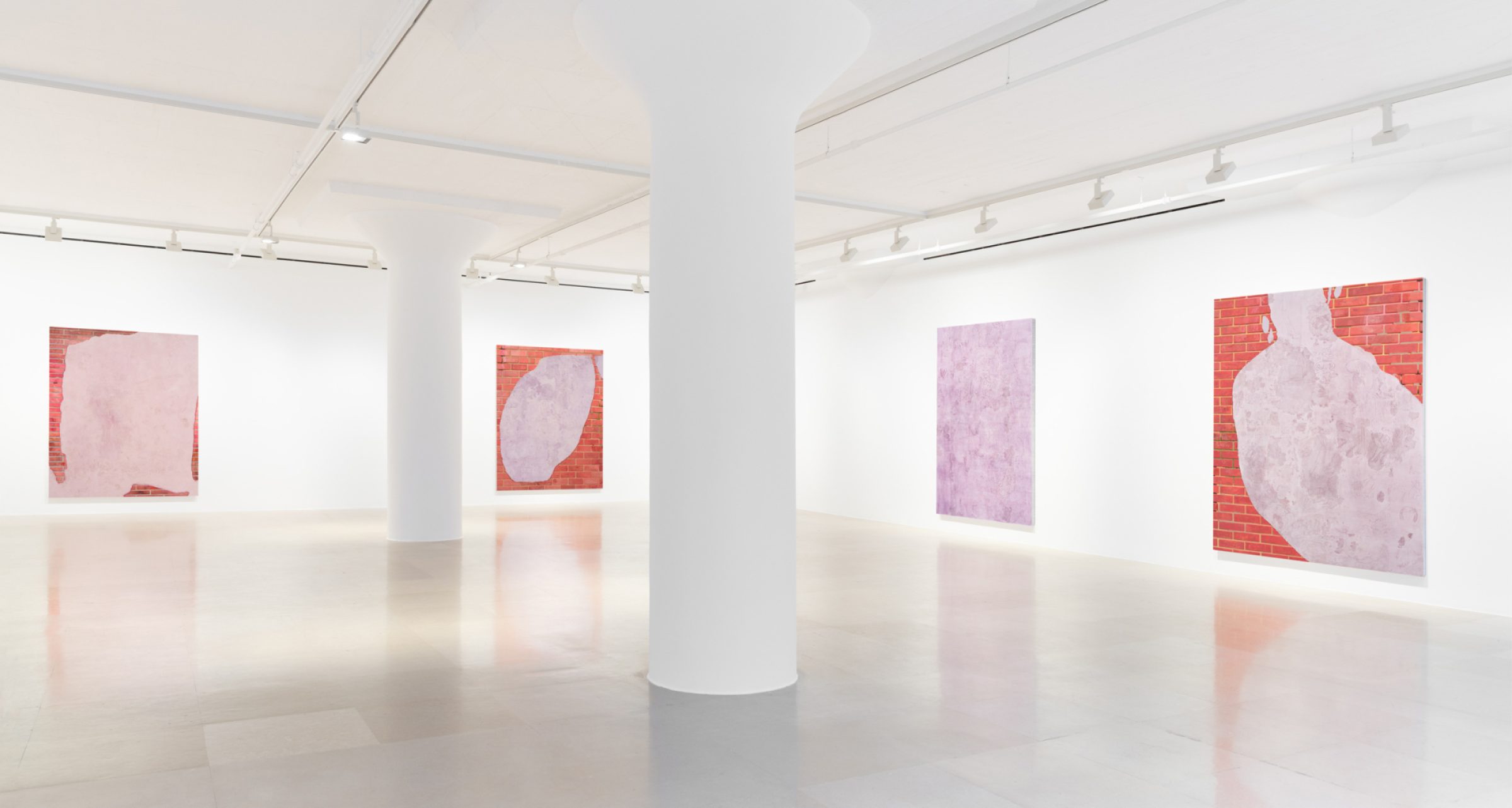 Gallery bisected by two pillars showing four paintings, three of which show a brick wall and a swath of lavender with drawings scratched into the surface, and one of which is a lavender monochrome.