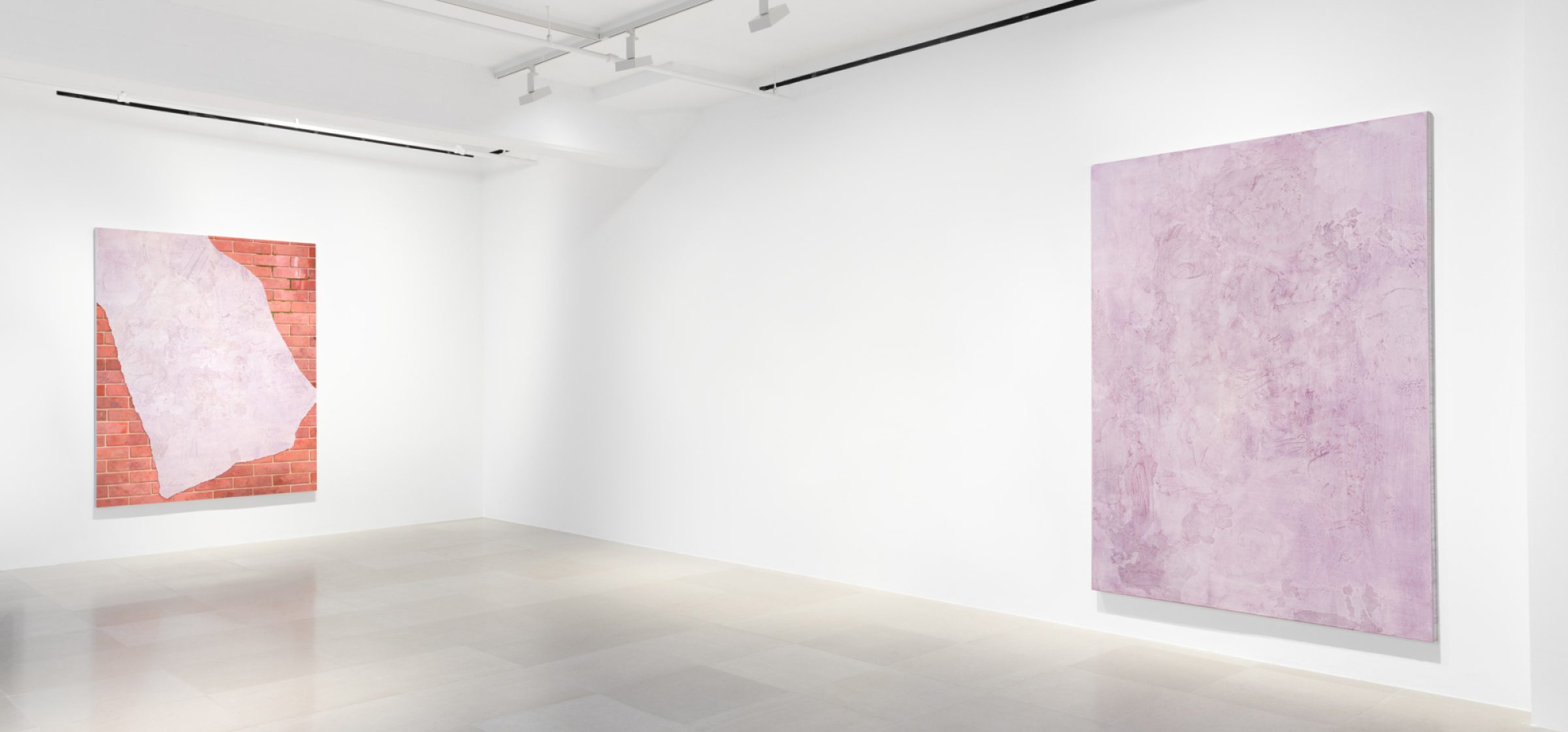 The corner of a gallery with a painting on each wall, on the right is a lavender monochrome with marks and drawings scratched into the surface,  on the left the painting shows a brick wall overlaid with a swath of lavender with marks and drawings scratched into the surface.